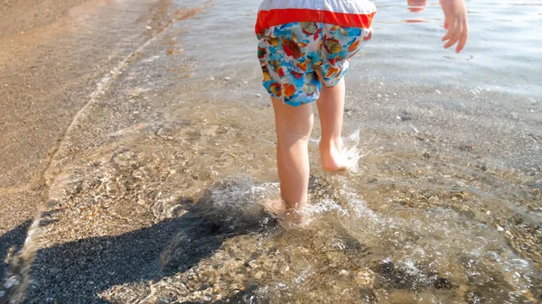 Sahilde deniz suyuna adım atan küçük küçük çocuğun closeup fotoğrafı — Stok fotoğraf
