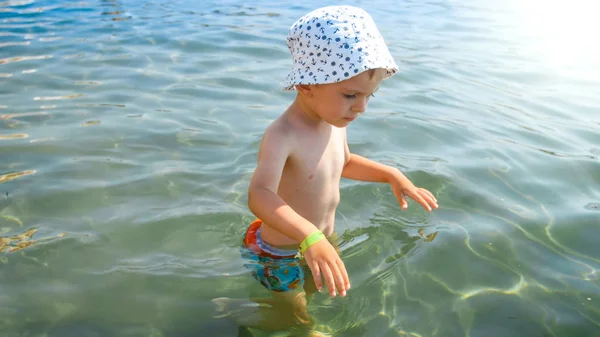Portrait of little toddler boy scared of water walking in sea — Stock Photo, Image