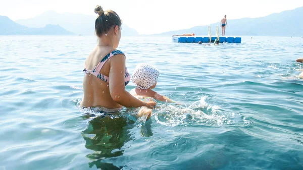Un niño nadando en el mar con su madre. Familia relajante en vacaciones de verano —  Fotos de Stock