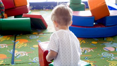 Küçük yürümeye başlayan çocuk alışveriş merkezinde kapalı playgrund oynuyor