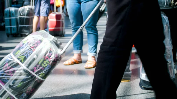 Нечеткое изображение людей, идущих с чемоданами в терминале аэропорта — стоковое фото