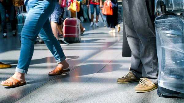 Foto fuera de foco de los pasajeros pies y bolsas en el suelo en la terminal del aeropuerto internacional — Foto de Stock