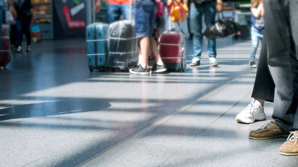 Fotos borradas de pessoas pés e sacos no chão à espera de voo no terminal do aeroporto — Fotografia de Stock