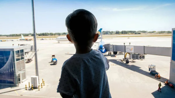 Silhueta de criança olhando em aviões andando na pista no aeroporto — Fotografia de Stock