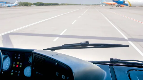 Widok z kabiny samochodowej jazdy na pasie startowym lotniska w kierunku samolotu — Zdjęcie stockowe