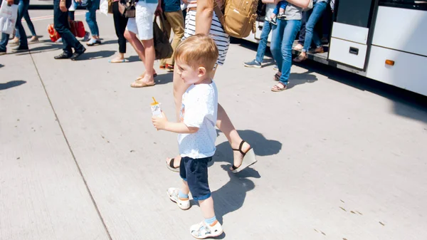 Cute smiling toddler boy holding mother by hand and walking out of the bus on airport runway — Stock Photo, Image