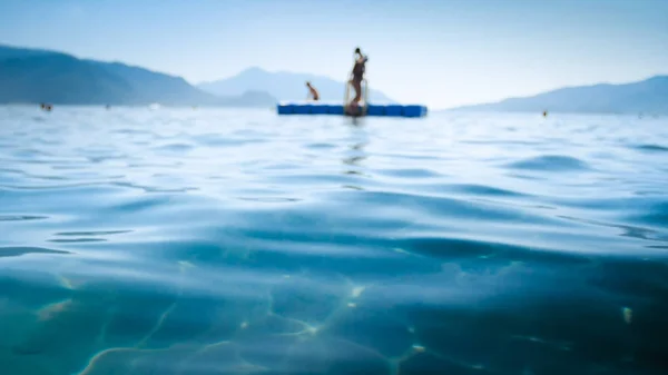 Uit focus beeld van kalme zee golven en drijvende ponton op zee — Stockfoto