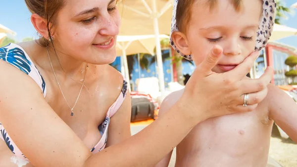 Närbild foto av yougn mamma med sin småbarn son med solskydd lotion på Sea Beach — Stockfoto