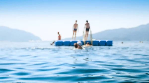 Imagen borrosa de la gente relajándose en el pontón flotante en el mar tranquilo —  Fotos de Stock