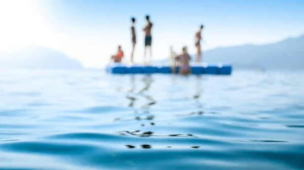 Blurred photo of floating platform in the calm sea waves at summer resort