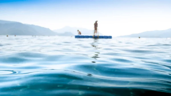 Imagen fuera de foco de olas de mar tranquilas contra muelle flotante —  Fotos de Stock