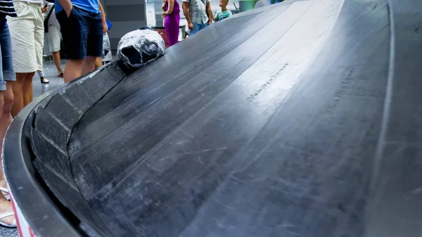 Крупный план толпы туристов, стоящих на пустой конвейерной ленте в ожидании багажа в аэропорту — стоковое фото