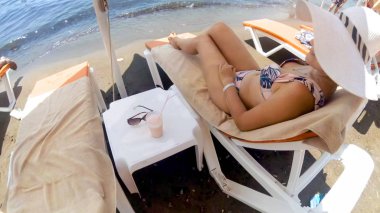 Deniz plajında şezlongüzerinde dinlenen güzel genç