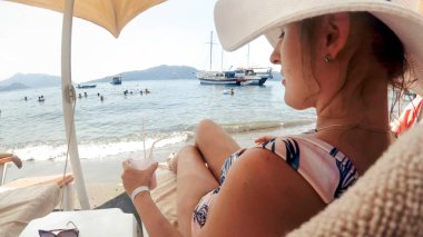 Deniz kenarında şezlongda dinlenen beeautiful genç kadın