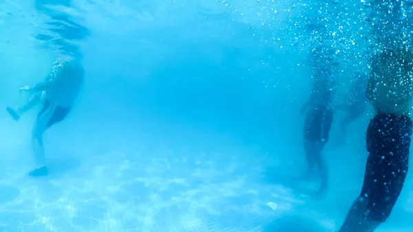 Vista da sott'acqua in piscina sulle persone che nuotano e si rilassano nella località estiva — Foto Stock