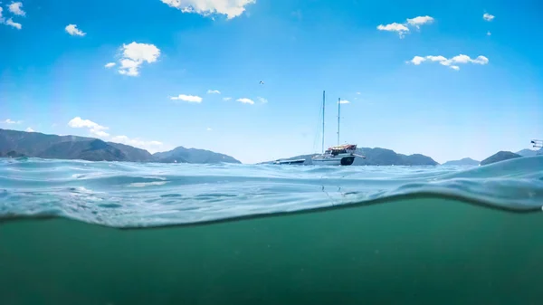 Image from under the water of yacht in sea against beautiful mountains — Stock Photo, Image