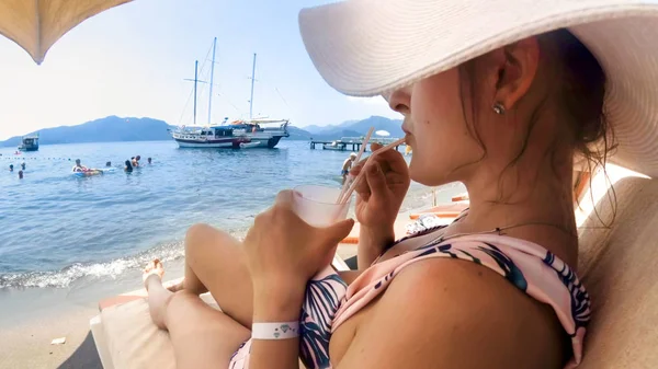 Rear view image of beautiful young woman lying on sunbed with cocktail — Stock Photo, Image