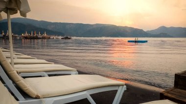 Gün batımında şezlong sıraları ile boş deniz plajı