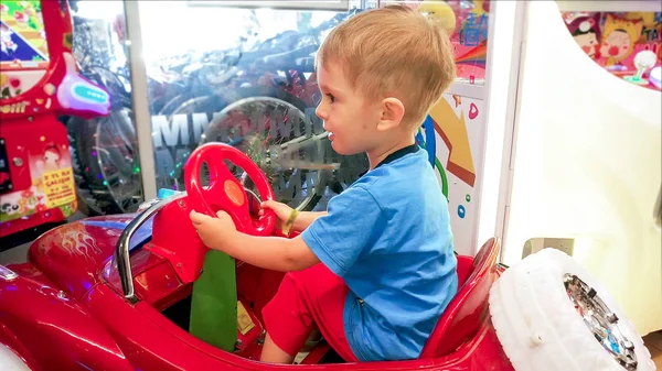 Menino pequeno feliz jogando no shopping center com carro de brinquedo — Fotografia de Stock