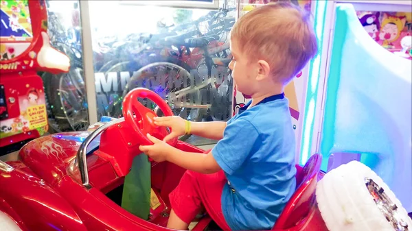 3 anos de idade criança menino sentado no carro de brinquedo no parque de diversões no shopping — Fotografia de Stock