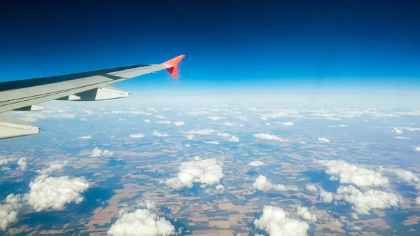 Vista desde el asiento del pasajero en el ala del avión y nubes contra el cielo azul — Foto de Stock