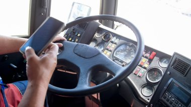 Araba kullanırken akıllı telefonu kullanan kamyon sürücüsünün yakın çekim görüntüsü. Ulaşımda tehlike. Sorumsuz sürücü