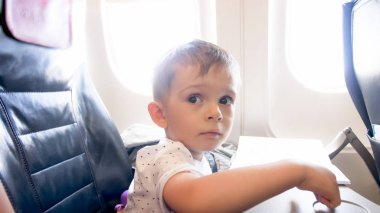 Uçakta ilk kez uçan büyük kahverengi gözlü küçük çocuğun portresi