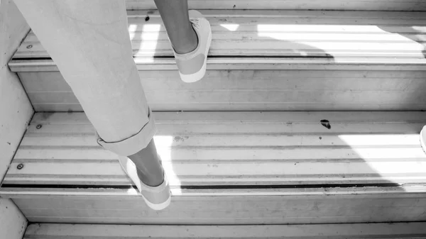 Svart och vit bild av kvinnliga fötter på flygplan doard trappor — Stockfoto