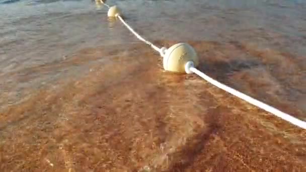 4k closeup video of line of buoys on the rope lying on the sandybeach — Stock Video