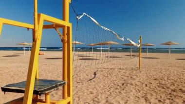Parlak güneşli bir günde altın kum ile deniz plajında voleybol sahası 4k video
