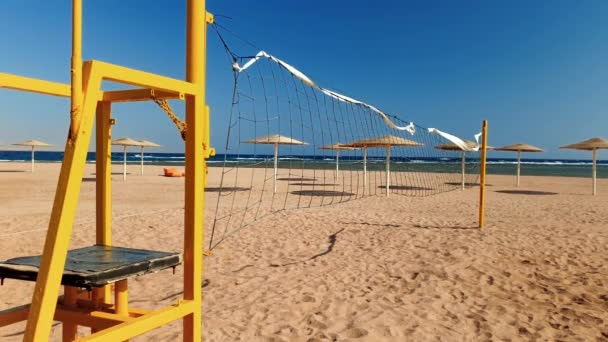 4k Video der Kamera bewegt sich entlang des leeren Strandes am Meer mit Feld für Volleyball bei strahlendem Sonnenschein — Stockvideo