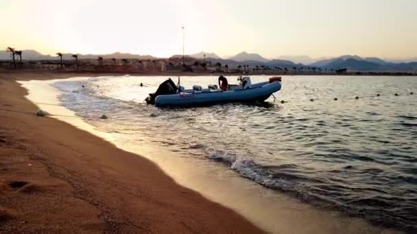 4k video van jonge man schoonmaken van zijn boot bij zonsondergang licht — Stockvideo