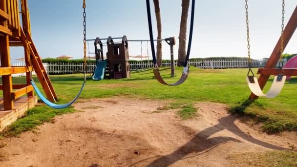 4K närbild bilder av Tom Swing på barnens lekplats bredvid havet stranden — Stockvideo