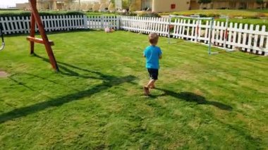Parkta th eplayground üzerinde çalışan ve topla oynayan neşeli küçük çocuk 4k video