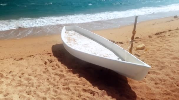 Fırtınalı bir günde kumlu deniz plajında beyaz ahşap tekne 4k video — Stok video