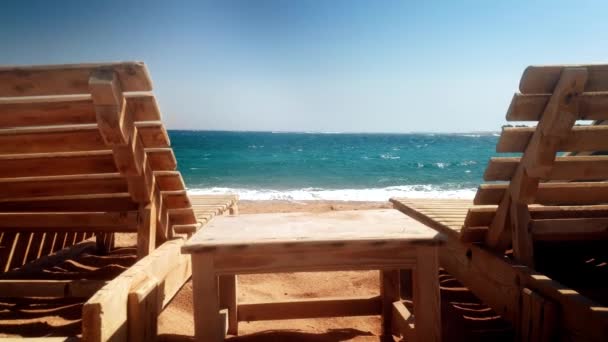4k-video van twee oude houten lounges op Sea Beach op Windy Day — Stockvideo