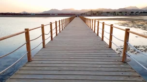 4k video of walking on the endless wooden pier in the ocean. Big waves rolling over the coast — Stock Video