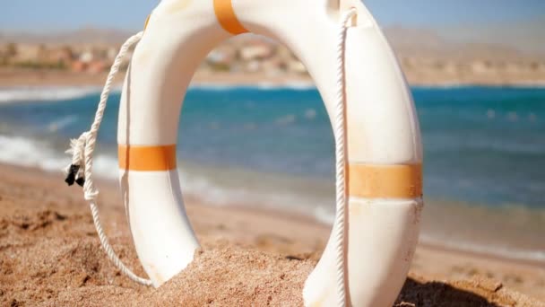 4k closeup footage of calm sea at bright sunny day. Camera looking through life saving ring buoy — Stock Video