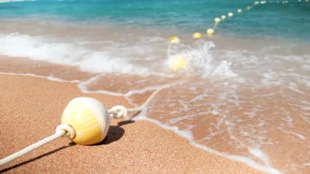 Vidéo au ralenti 4k des vagues de mer bleue percer sur la ligne de bouées à la plage — Video