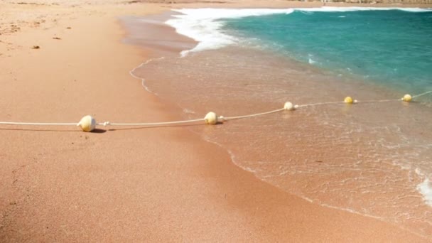 4k Zeitlupe Video von blauen Meereswellen brechen auf Linie der Bojen am Strand — Stockvideo