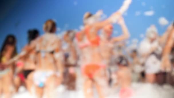 石鹸のビーチパーティーで踊る陽気な群衆の4Kぼかしビデオ。石鹸の泡が飛び回る. — ストック動画