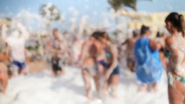 4К размыло видео, где веселая толпа танцует на мыльной пляжной вечеринке. Мыльные пузыри летают вокруг . — стоковое видео