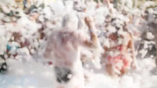4k fuera de foco metraje de personas bailando en la fiesta de espuma de jabón al aire libre. Divertirse y relajarse en las vacaciones de verano — Vídeo de stock