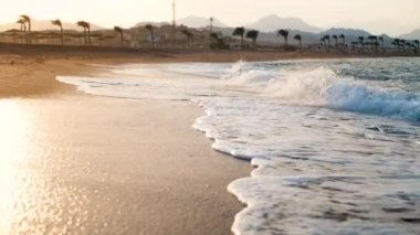 Kumlu plajda kırma büyük deniz dalgaları 4k yavaş çekim video. Okyanus üzerinde güzel gün batımı