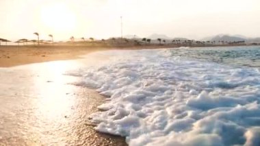 Kumlu plajda kırma büyük deniz dalgaları 4k yavaş çekim video. Okyanus üzerinde güzel gün batımı