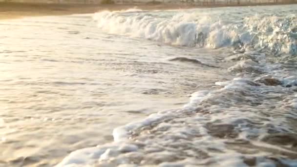 Slow motion video of big ocean waves breaking on the sandy beach in susnet sun rays — Stock Video