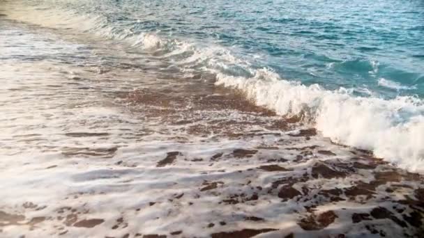 Extrem slow motion video av havsvågor rullande på den gyllene sandstranden vid solnedgången — Stockvideo