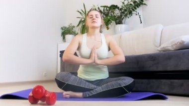 Fiziksel egzersizler yaptıktan sonra fitness mat üzerinde meditasyon güzel genç kadın 4k görüntüleri
