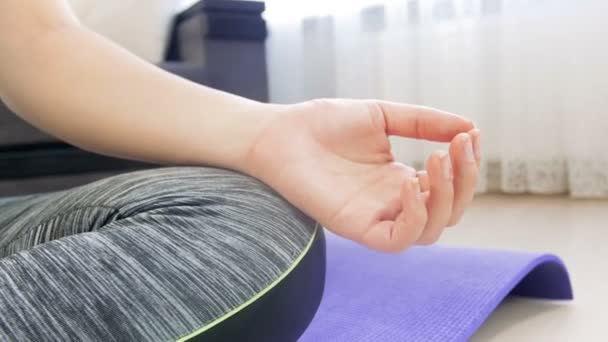 4k closeup dolly vídeo of young woman sitting in lotus asana and meditating. Menina praticando ioga em casa — Vídeo de Stock