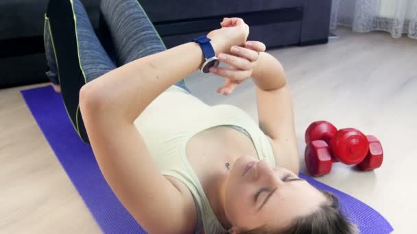 Imágenes de 4k de una joven deportista ajustando y ajustando el reloj de pulsera de seguimiento de fitness antes de hacer ejercicios deportivos — Vídeo de stock